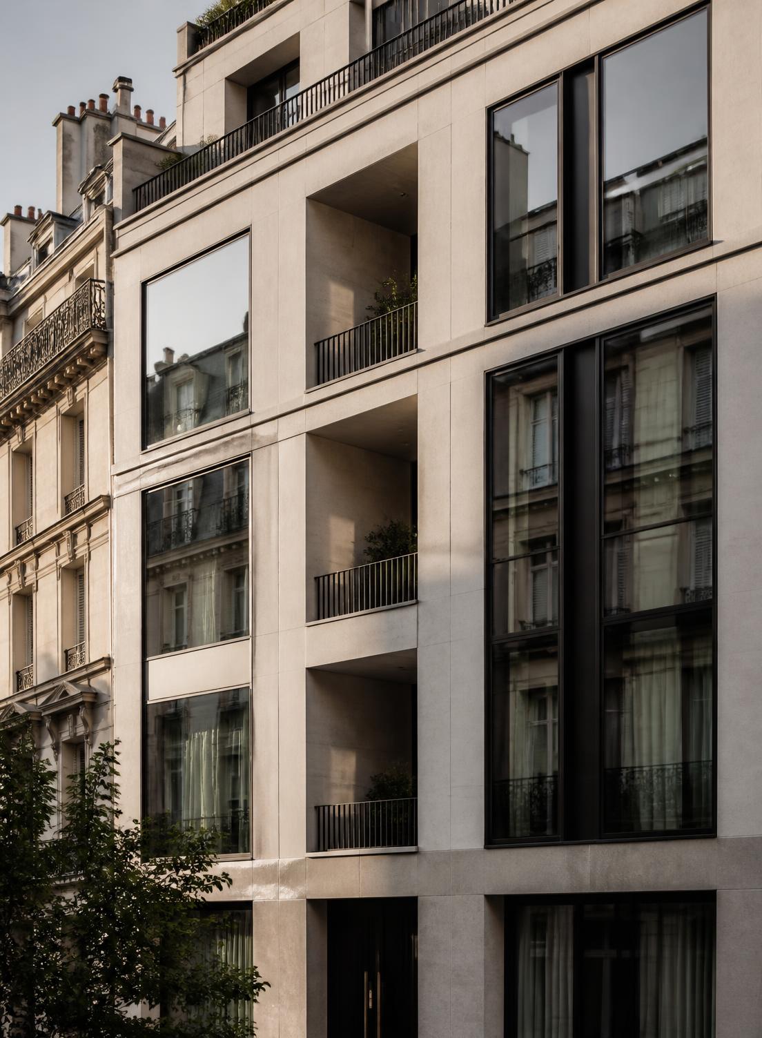 Façade contemporaine en pierre et verre d'un immeuble résidentiel parisien